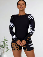 Black long-sleeve rash guard top with tan-and-brown abstract leaf boy shorts