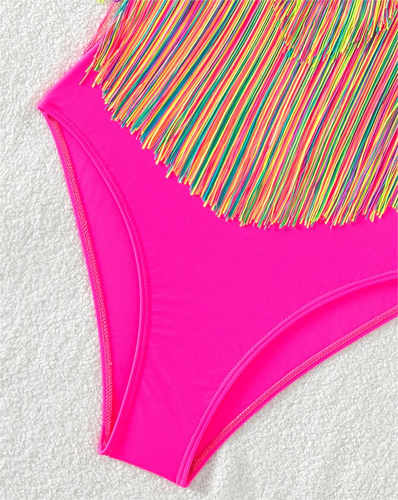 Bright pink one-piece swimsuit with rainbow fringe detail at the bust and legs