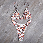 Leopard print bikini set laid flat: triangle bra and Brazilian cut thong bottoms