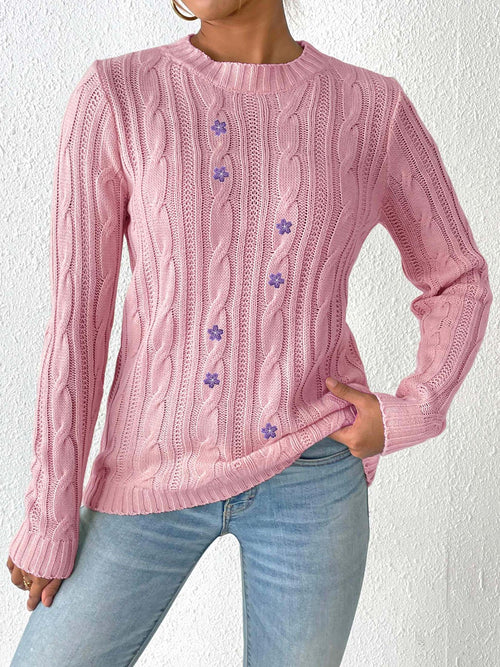 Pink cable-knit sweater with round neck and purple floral accents down center