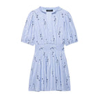 Light blue spring dress with short puff sleeves, gathered smocked waist, and navy animal print
