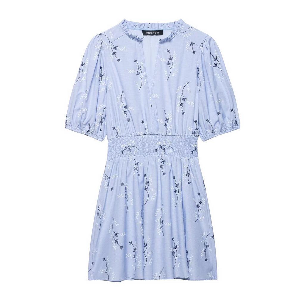 Light blue spring dress with short puff sleeves, smocked waist, and scattered navy animal print