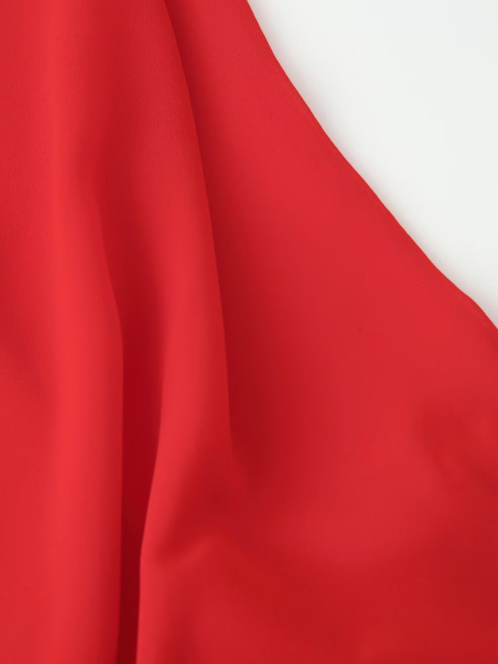 Red halter maxi dress skirt close-up with flowing fabric drape