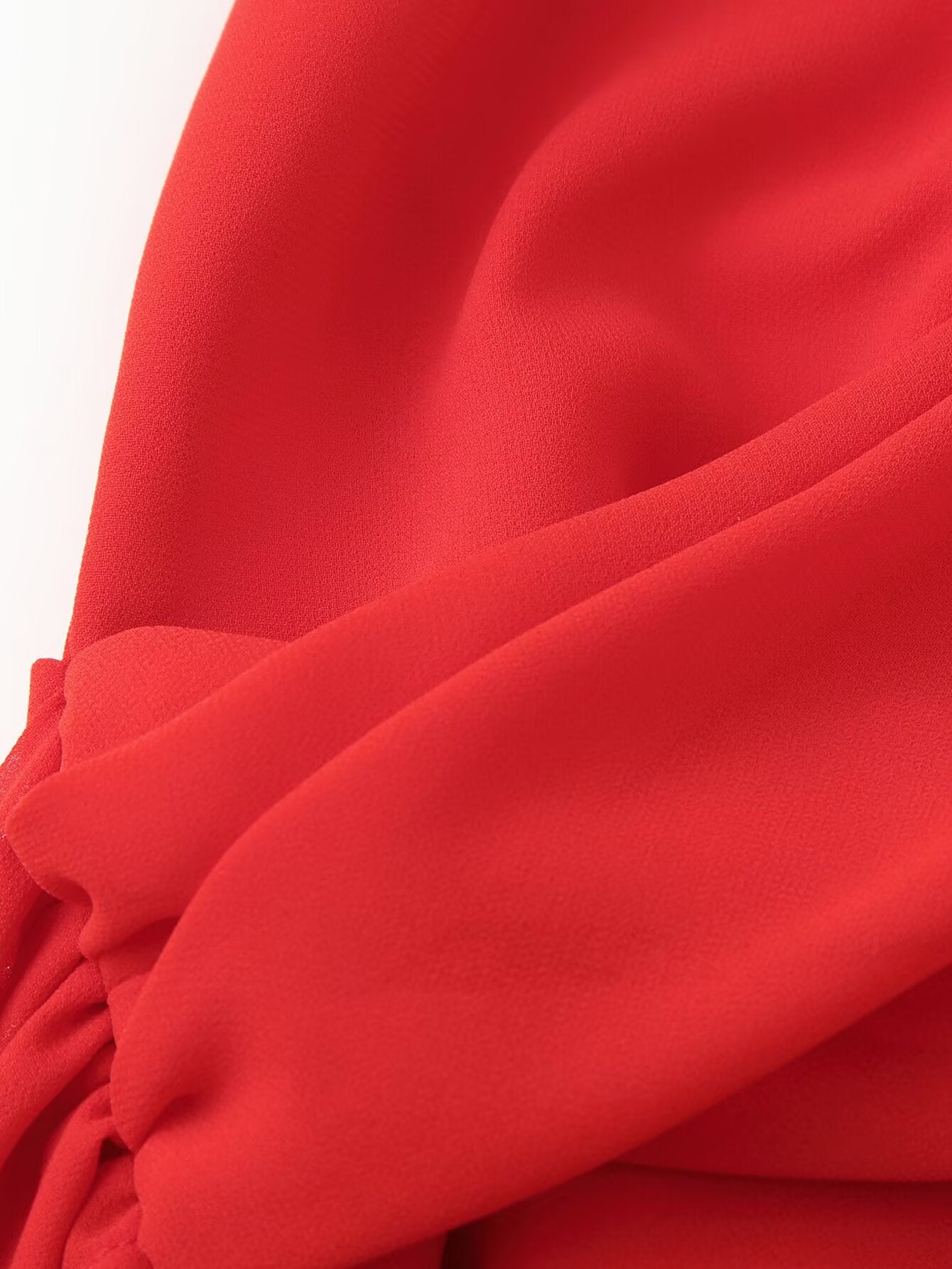 Red halter dress close-up of gathered shoulder and smooth draped fabric