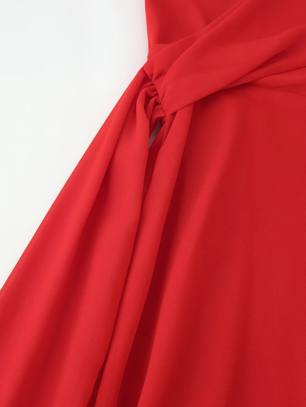 Red halter maxi dress close-up of waist knot and flowing side drape