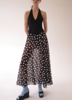 Black sleeveless halter dress with deep V neckline and white polka dot skirt