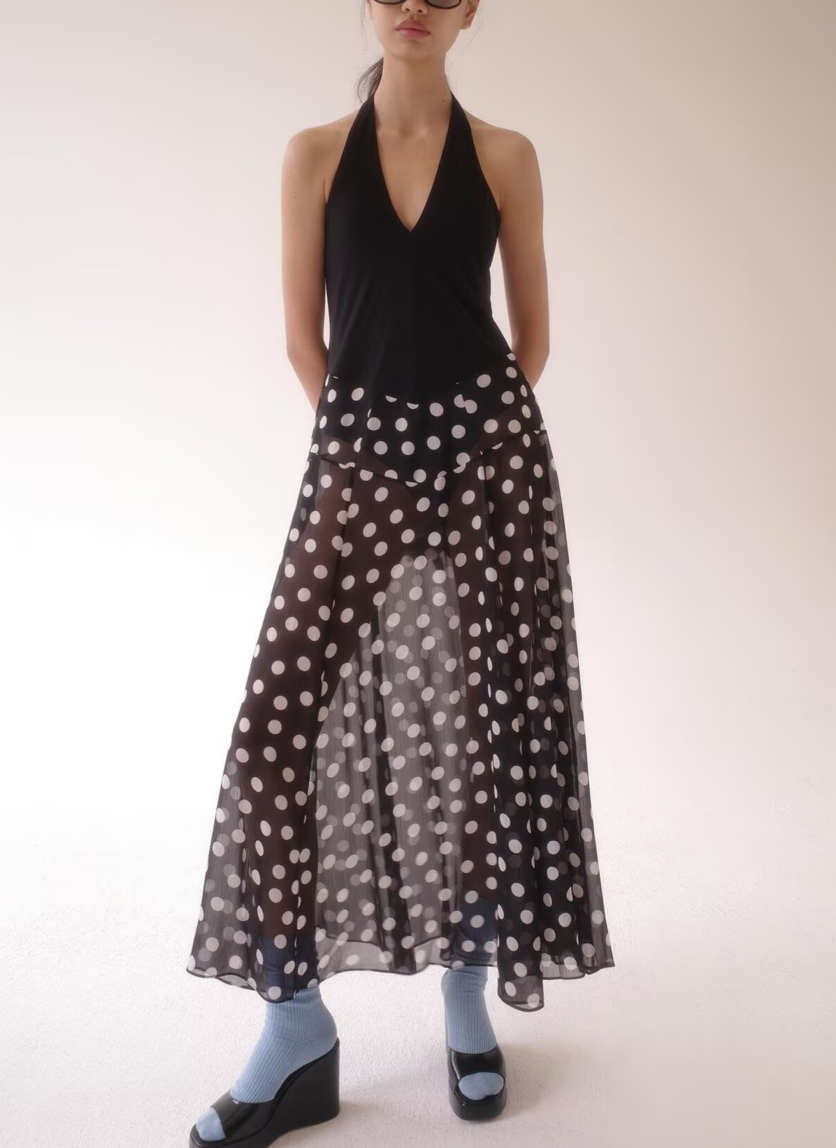 Black sleeveless halter dress with deep V neckline and white polka dot skirt