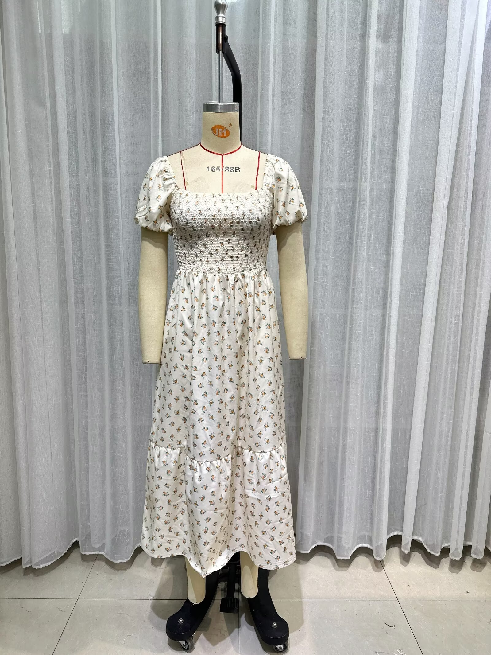 Cream short-sleeve dress on mannequin, square neckline, puff sleeves, smocked bodice