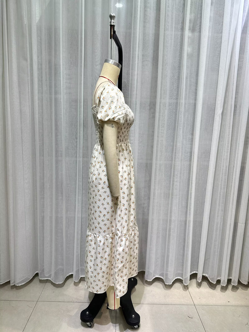 Cream short-sleeve tiered dress side view, puff sleeves and smocked bodice with tiny print