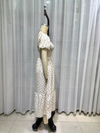 Cream short-sleeve tiered dress side view, puff sleeves and smocked bodice with tiny print