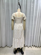 Cream short-sleeve dress back view on mannequin, smocked waist, tiered skirt