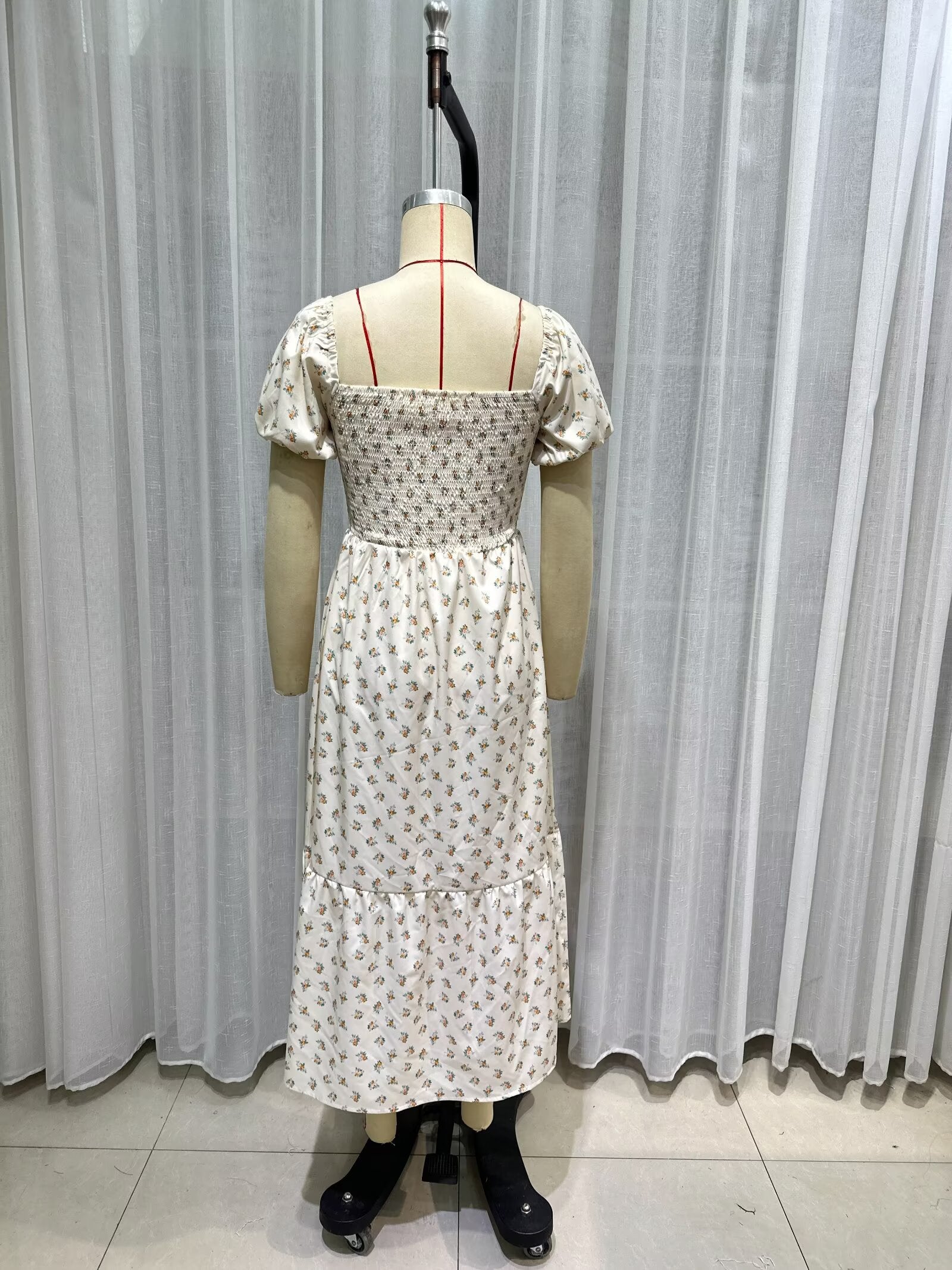 Cream short-sleeve dress back view on mannequin, smocked waist, tiered skirt