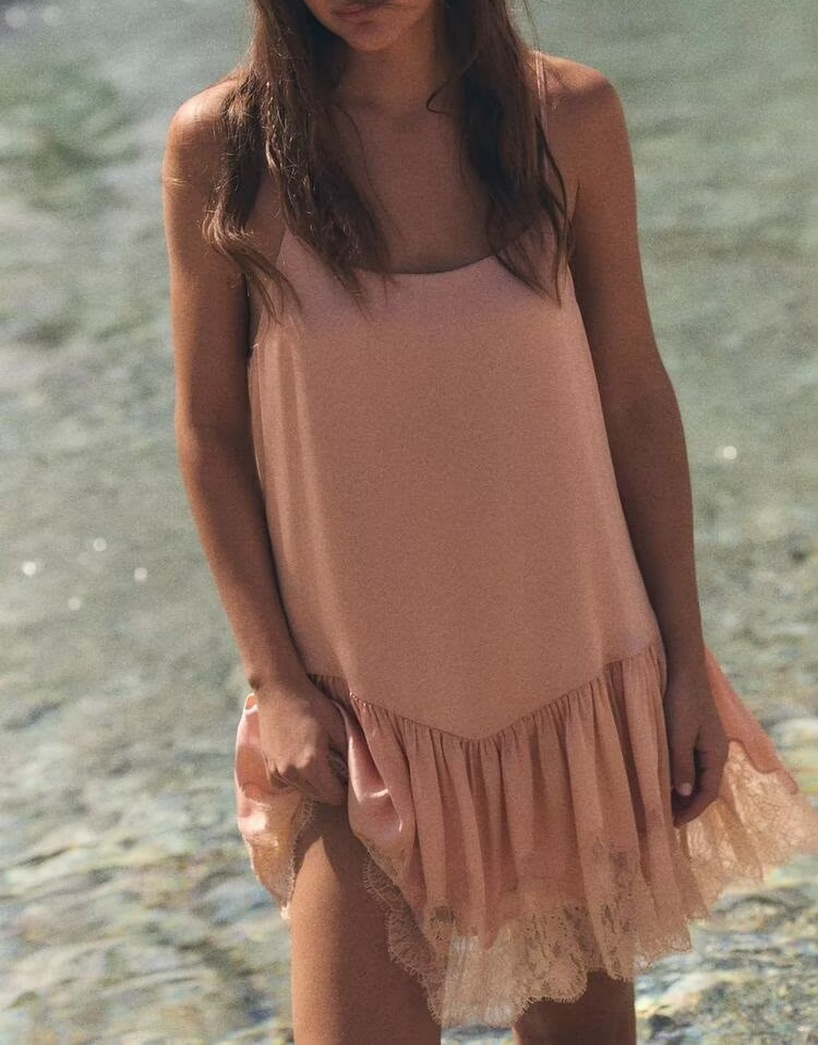 Pink lace satin slip dress with spaghetti straps and tiered lace-trimmed hem