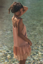 Pink lace satin slip dress with sleeveless spaghetti straps and tiered lace hem