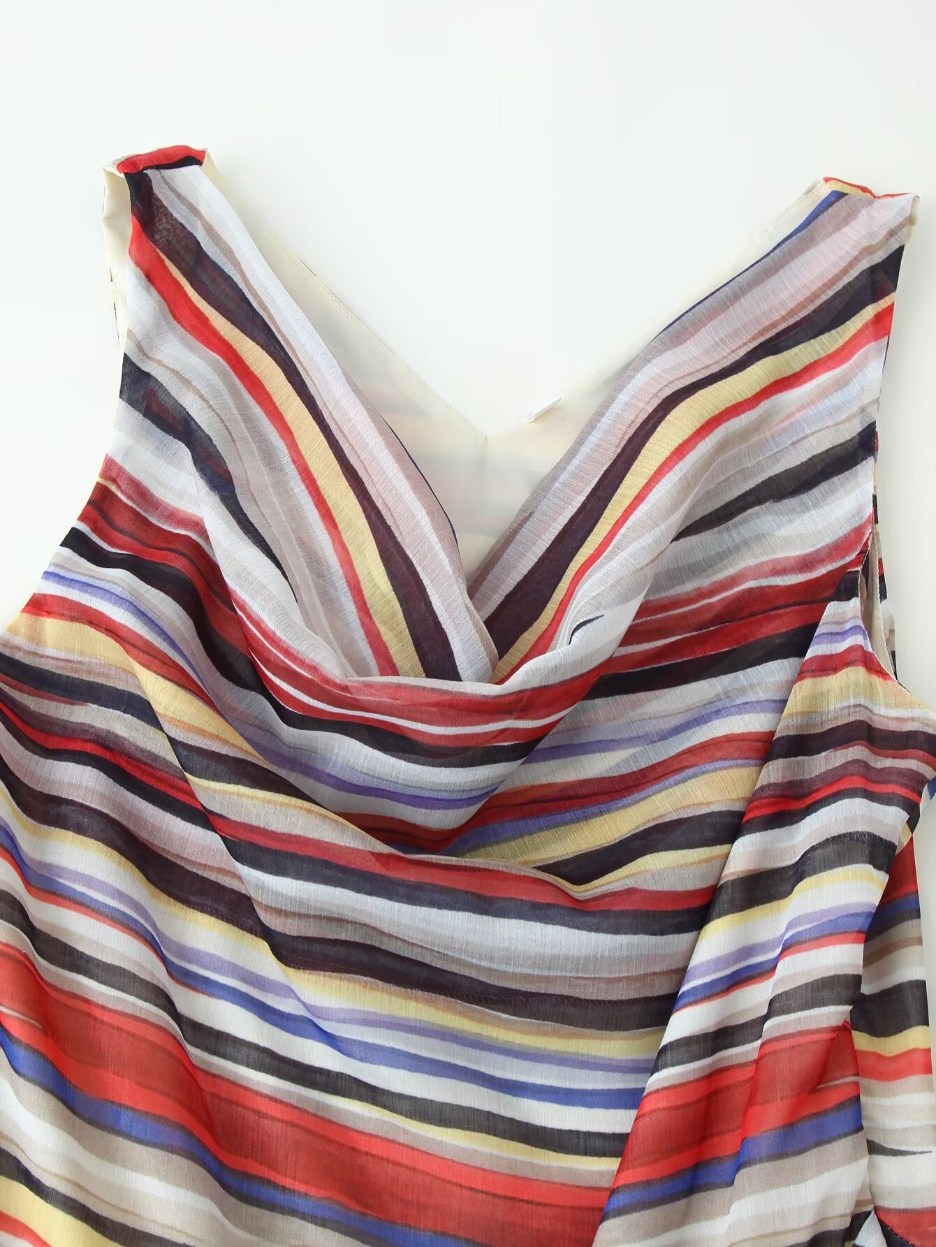 V-neckline detail of multicolor striped sleeveless dress with draped fabric