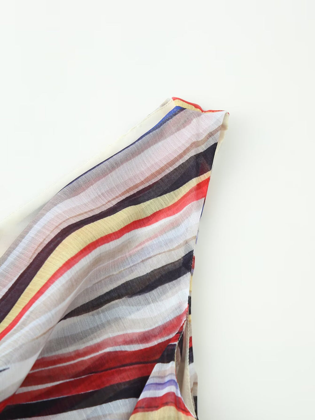 Side detail of multicolor striped sleeveless dress with flowing asymmetrical hem