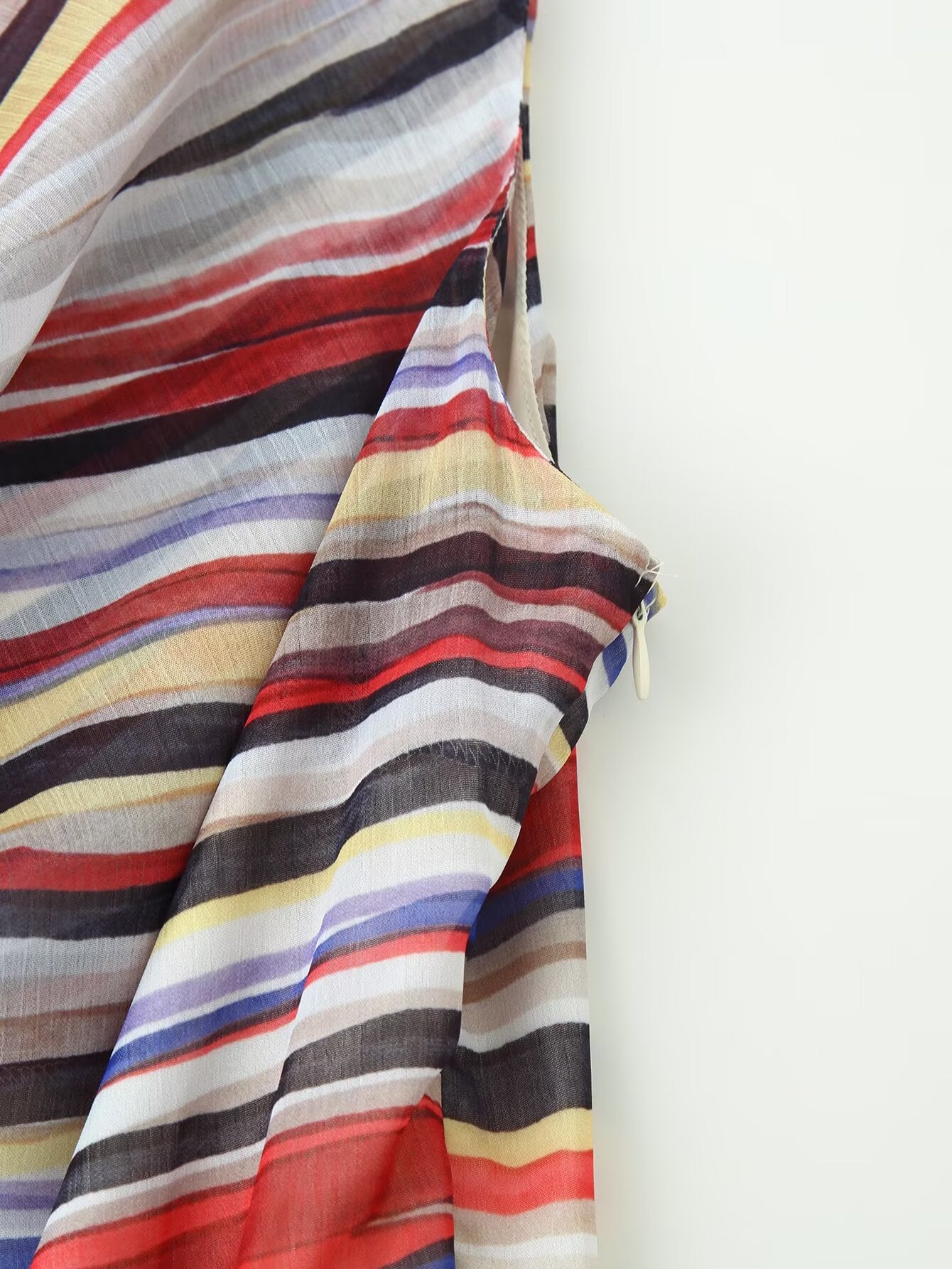 Close-up of multicolor striped fabric on sleeveless dress, draped folds