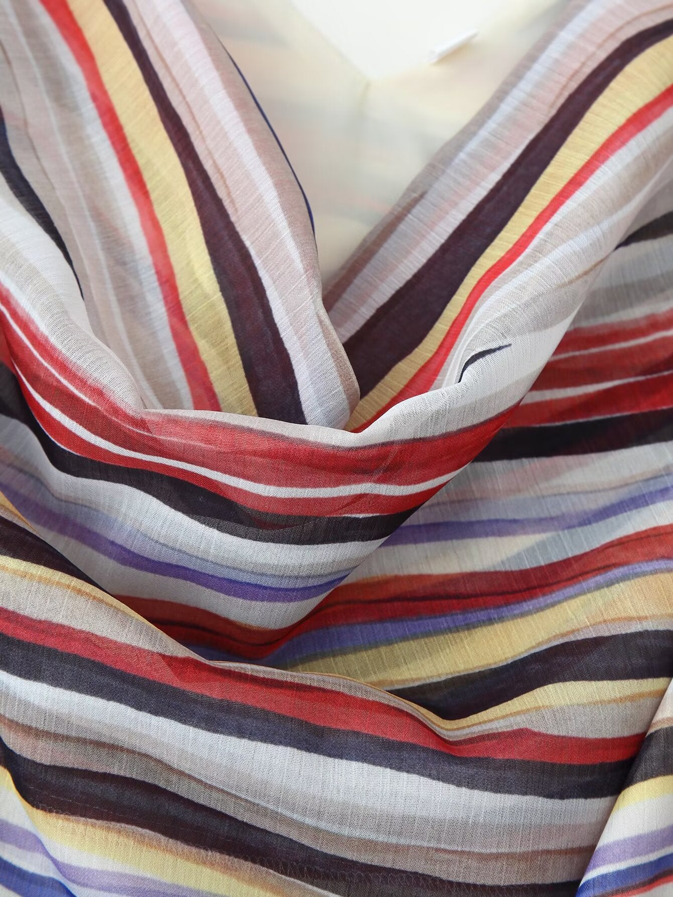 Close-up of V-neck draped multicolor striped fabric on sleeveless dress