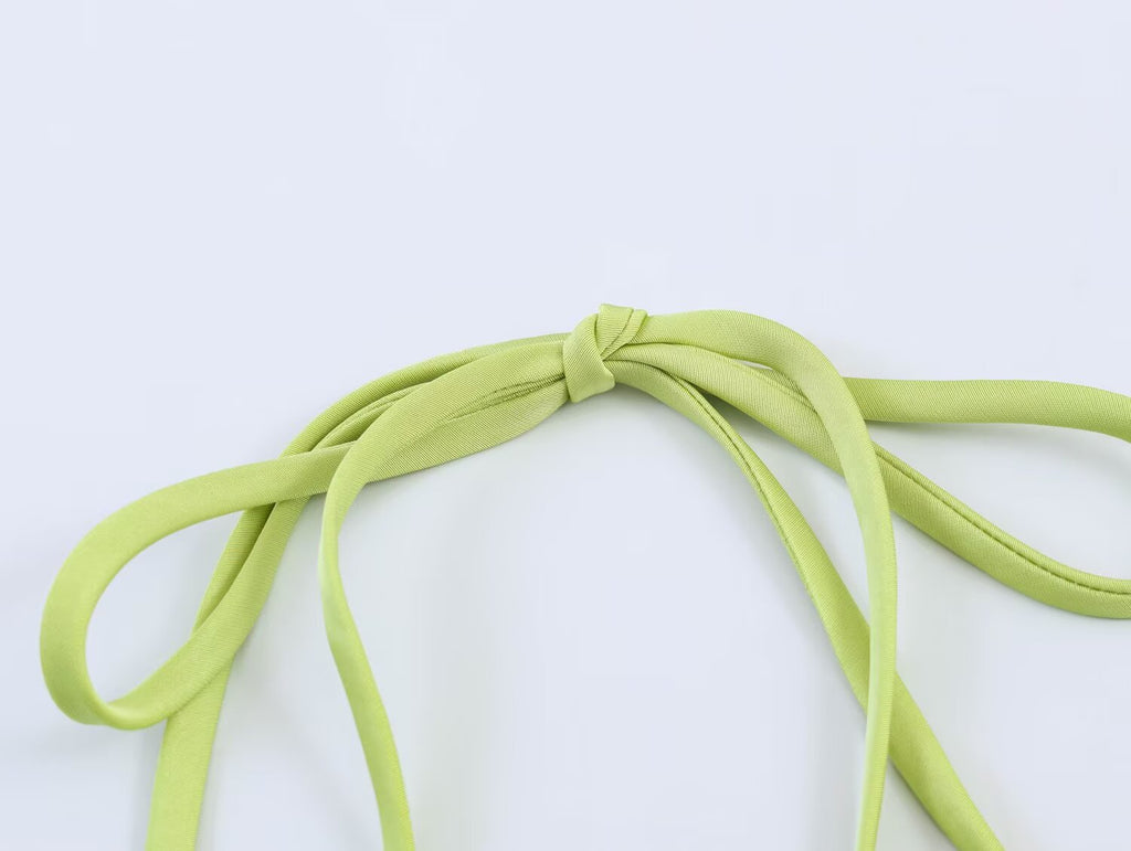 Green tie straps and bow detail at satin bodice, close-up