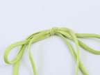 Green tie straps and bow detail at satin bodice, close-up
