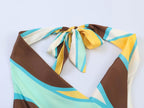 Geometric pleated dress close-up of bow tie at open-back halter neckline