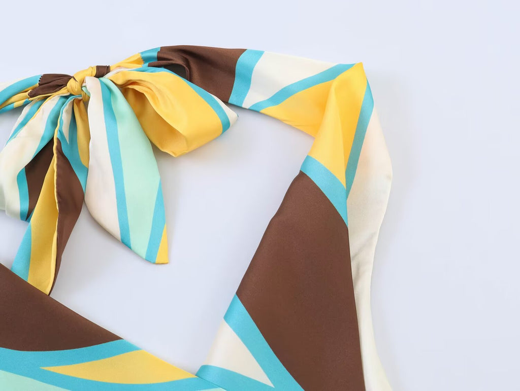 Pleated halter dress close-up of bow tie and colorful geometric panels at shoulders