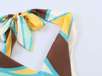 Pleated halter dress close-up of bow tie and colorful geometric panels at shoulders