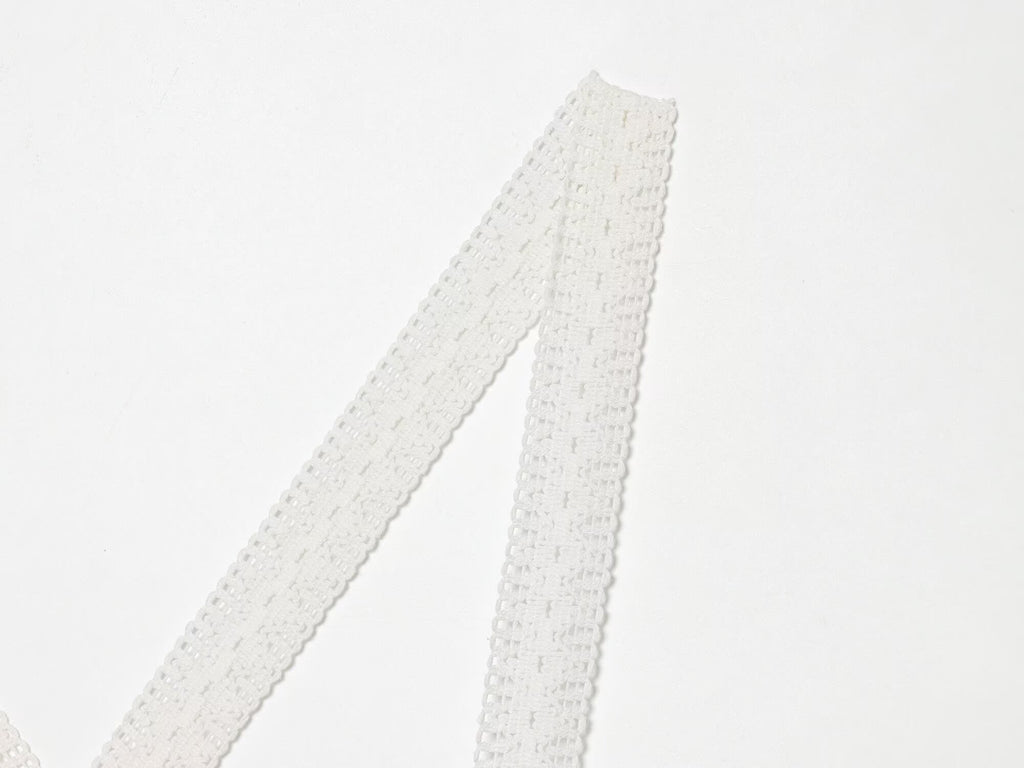White spaghetti straps with lace texture on mini summer dress, close-up of strap ends
