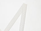 White spaghetti straps with lace texture on mini summer dress, close-up of strap ends