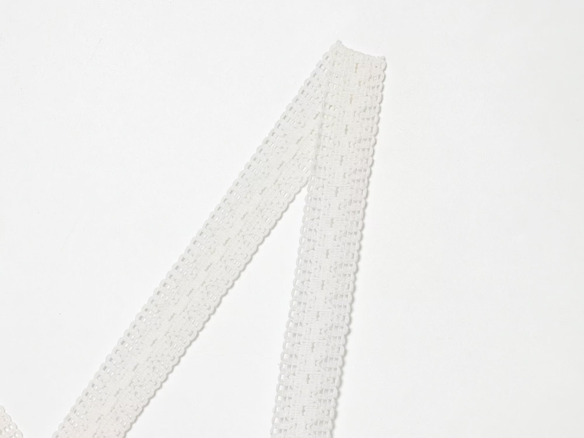 White spaghetti straps with lace texture on mini summer dress, close-up of strap ends