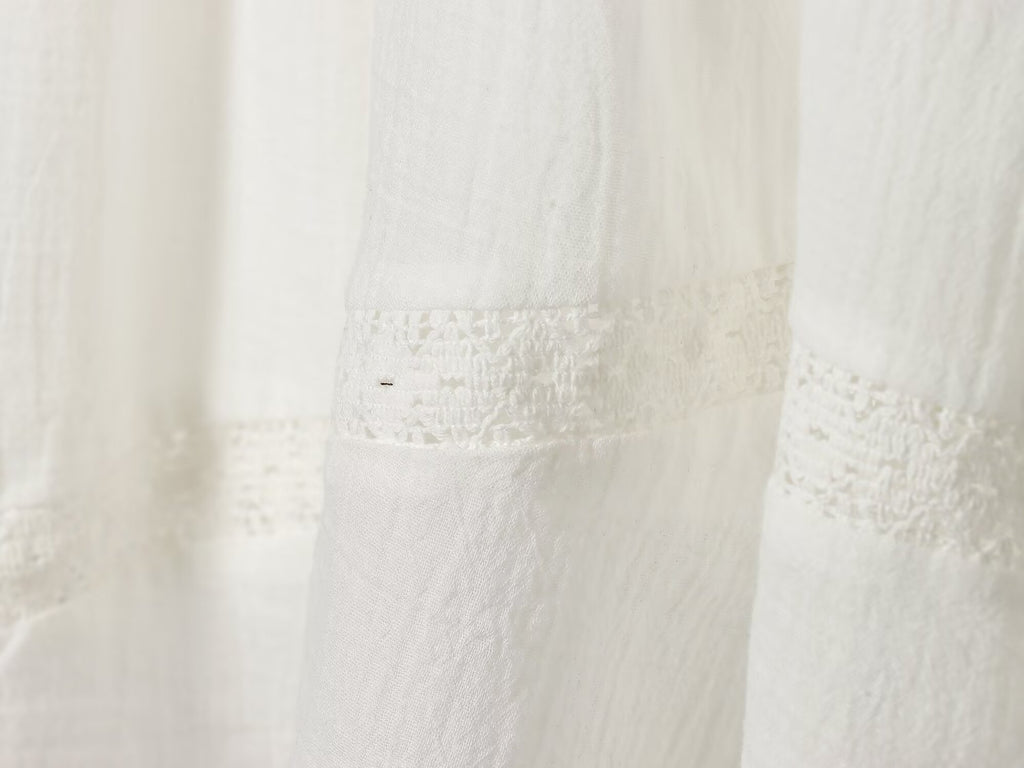 White mini summer dress with ruched side panel and lace trim at hem
