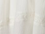 White mini summer dress with ruched side panel and lace trim at hem