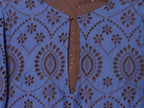 Blue embroidered dress close-up showing keyhole neckline and button detail