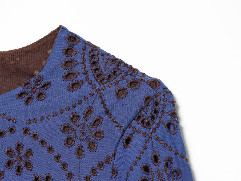 Blue embroidered dress close-up with V-shaped sleeve seam and patterned fabric