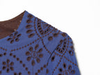 Blue embroidered dress close-up with V-shaped sleeve seam and patterned fabric