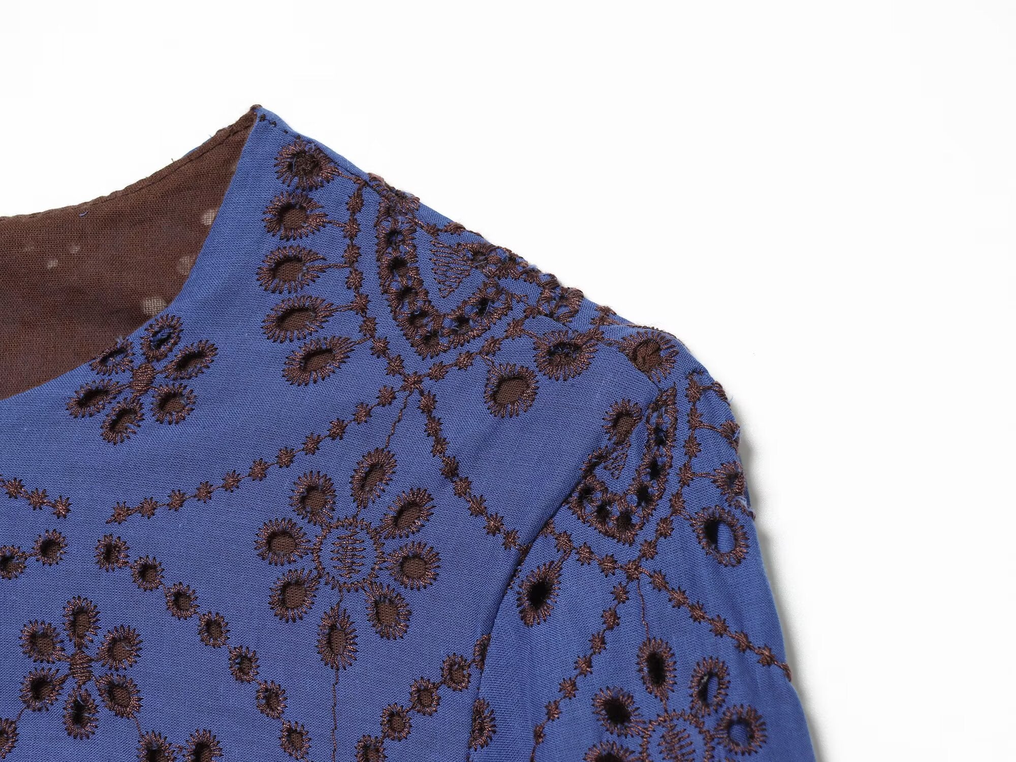 Blue embroidered dress close-up with V-shaped sleeve seam and patterned fabric