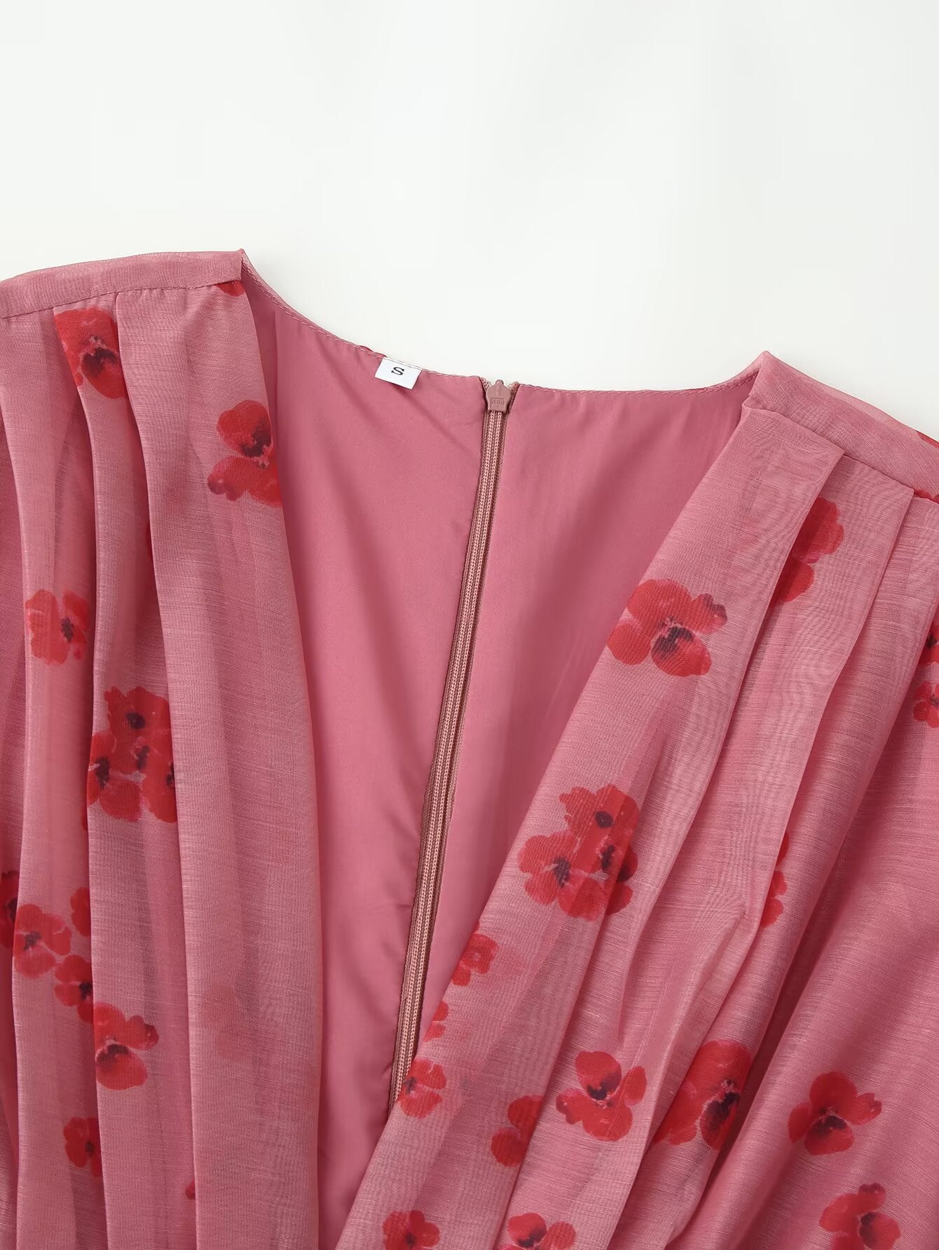 Pink dress close-up with red floral print, V-neck and front zipper