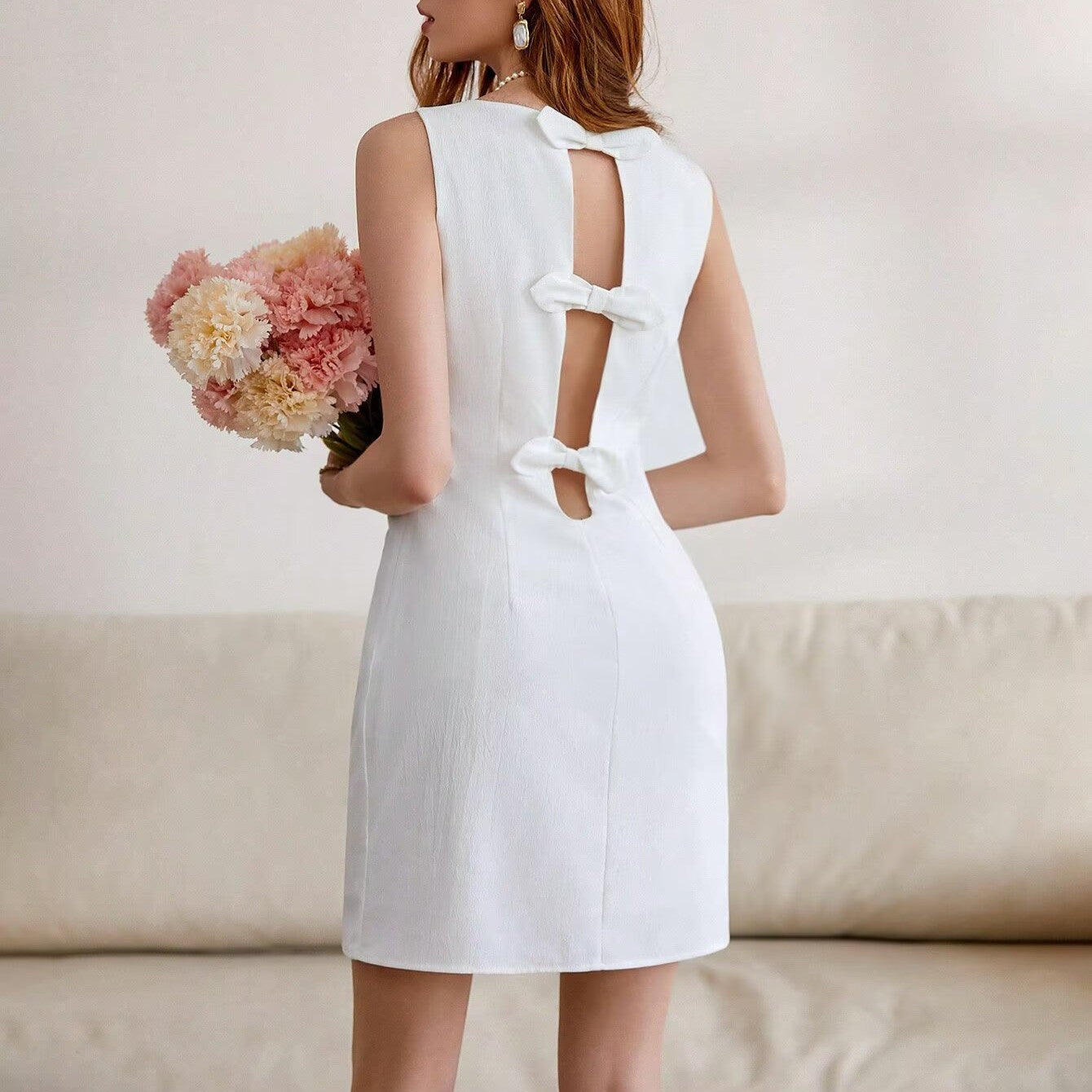 White women's elegant backless dress with keyhole cutout and bow-tie back
