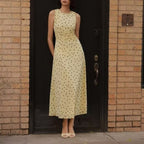 Yellow sleeveless polka-dot midi dress with round neckline and fitted waist