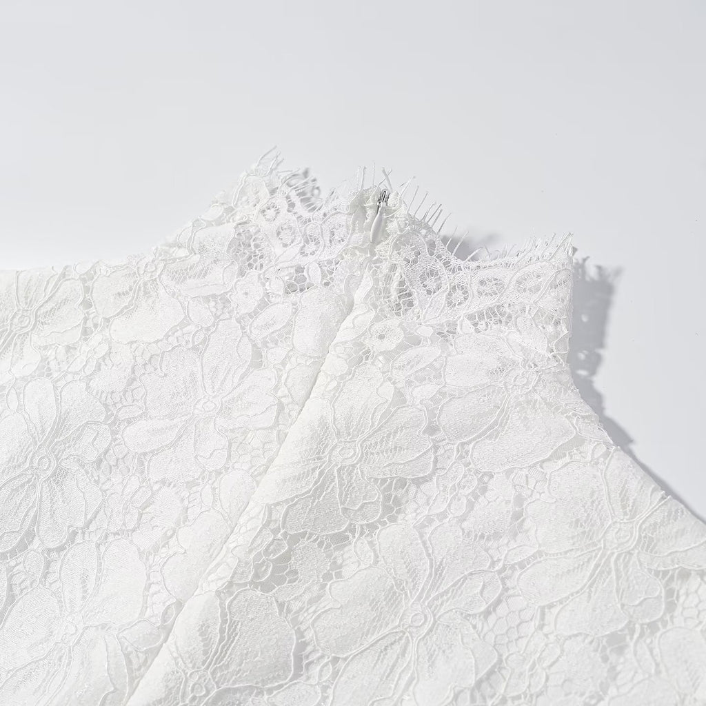 Close-up of white lace bodice with high neckline and scalloped detailing
