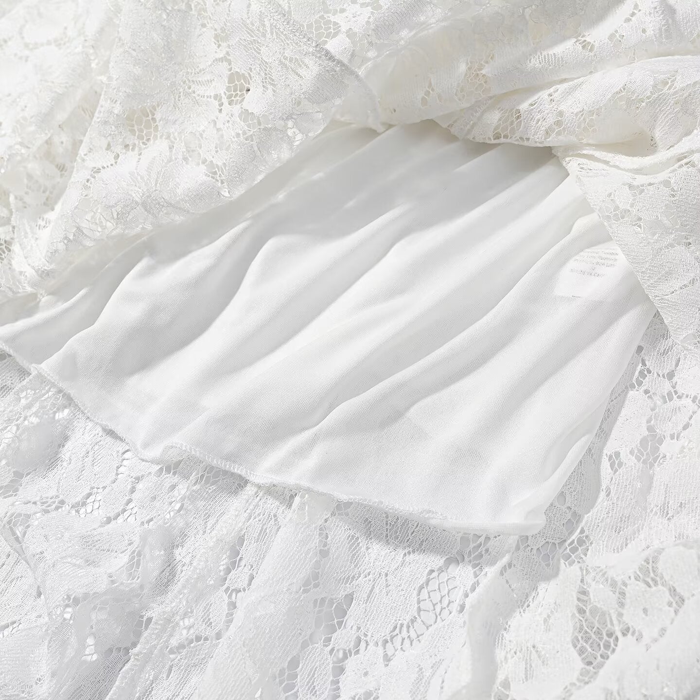 White lace dress overlay over satin-like inner skirt with gathered ruffle