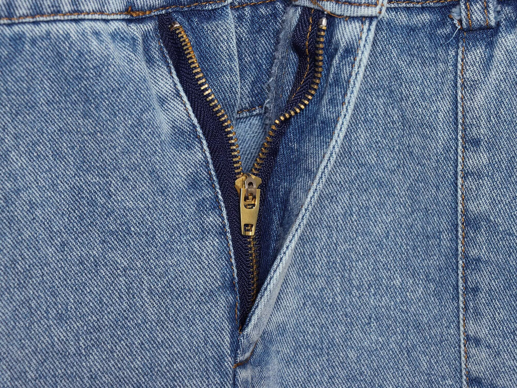 Close-up of blue denim halter dress button placket with gold-tone zipper