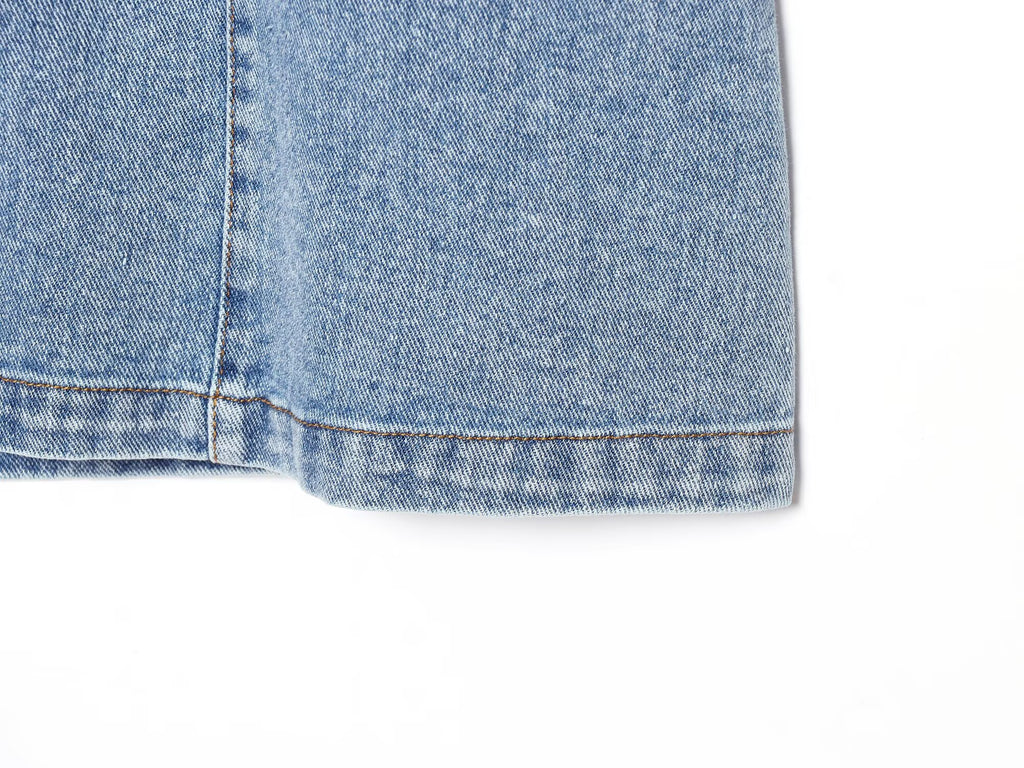 Hem of blue denim halter mini dress with frayed cuff edge