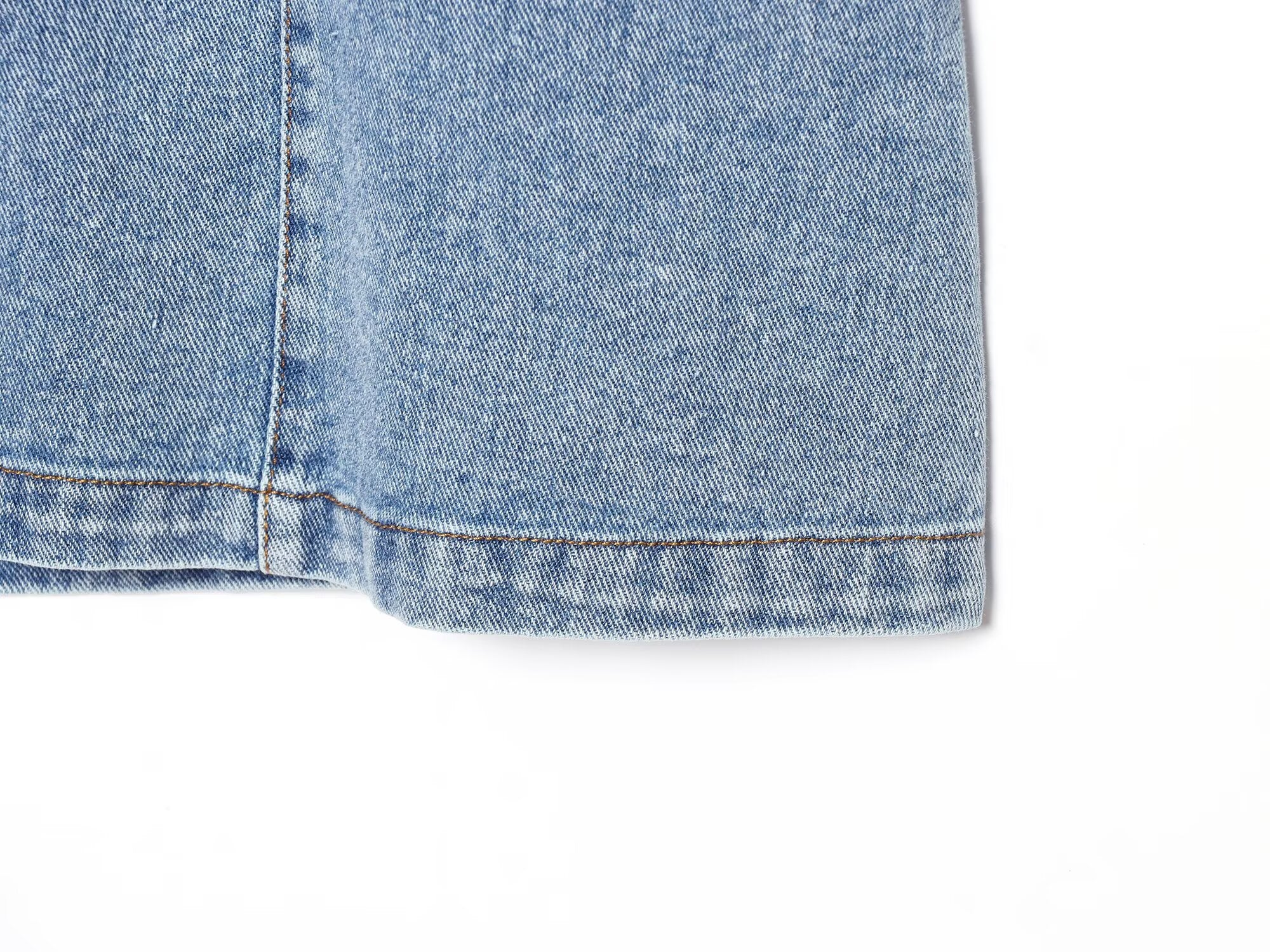 Hem of blue denim halter mini dress with frayed cuff edge
