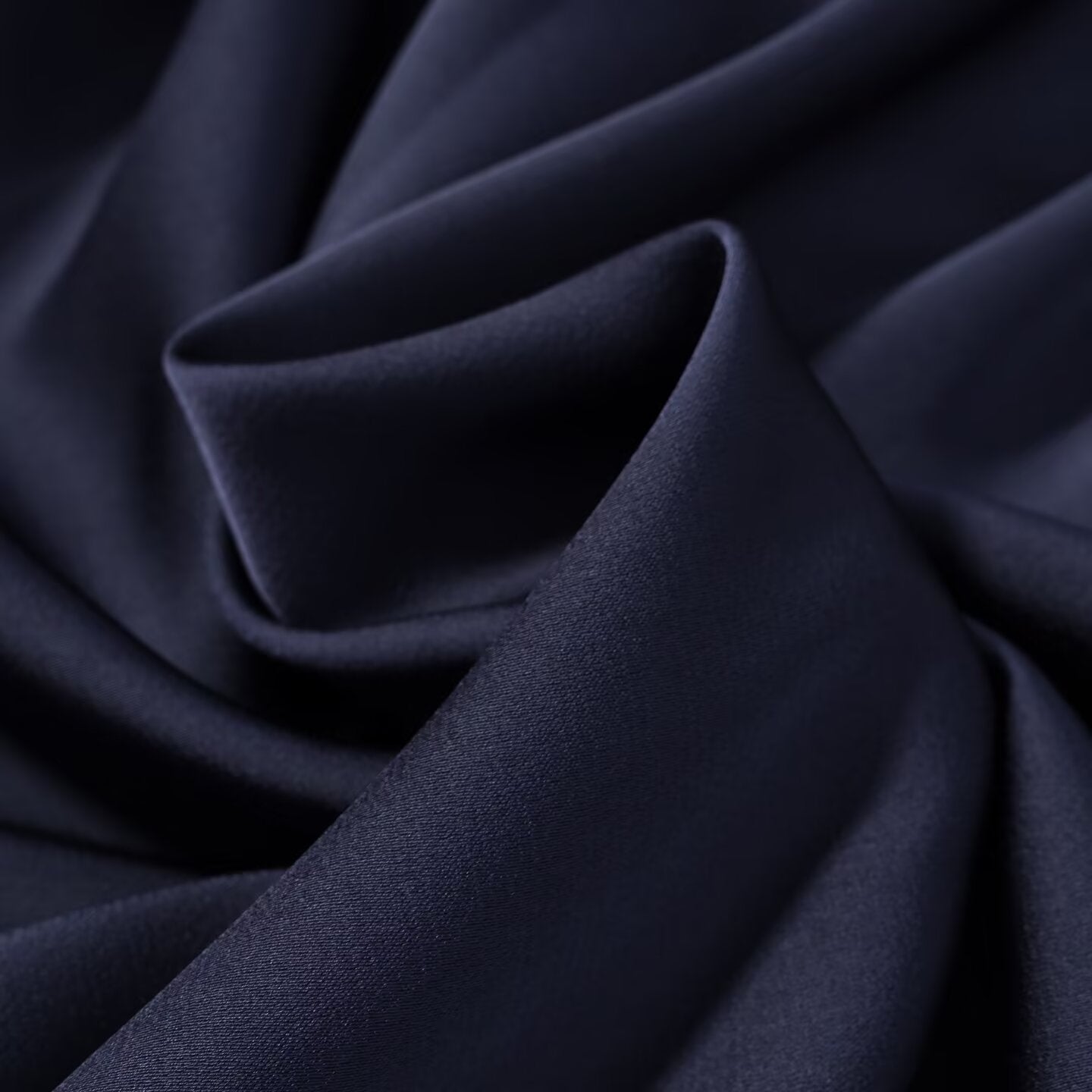Navy satin-like fabric close view with soft folds and smooth texture