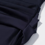 Navy blue pleated skirt with layered fabric panels and gathered detail