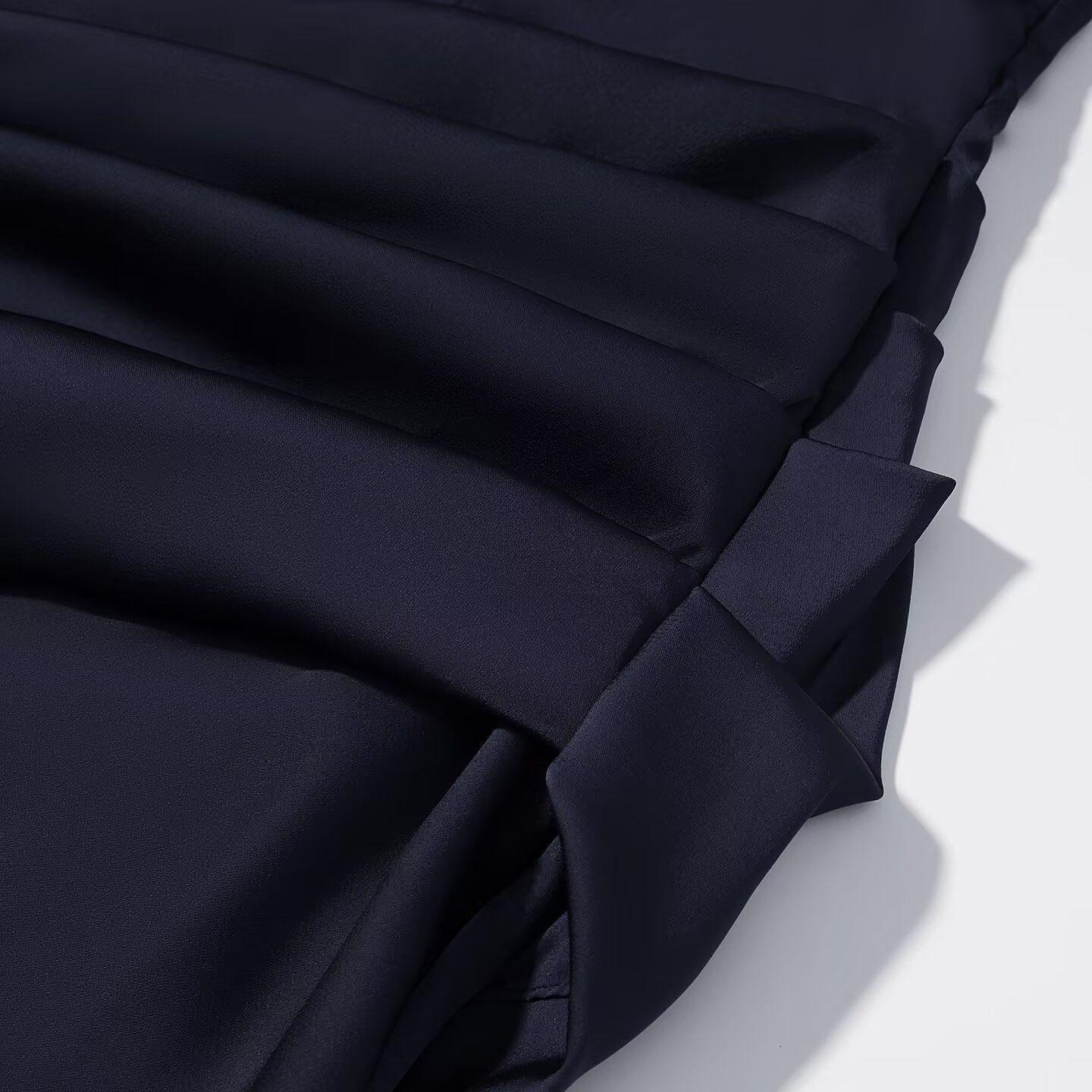 Navy blue pleated skirt with layered fabric panels and gathered detail