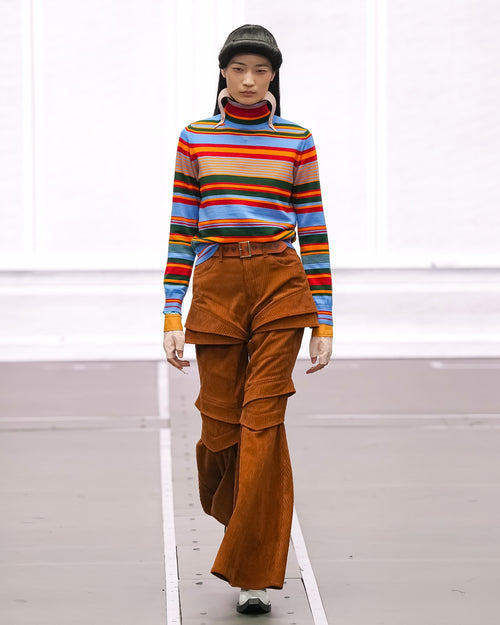 Women’s striped turtleneck knit pullover with rainbow horizontal stripes and ribbed cuffs.