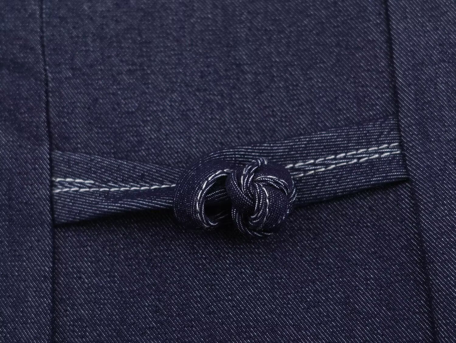 Deep blue denim button placket with twisted rope-button detail