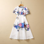 White floral sequin dress on hanger, short sleeves, gathered waist, full skirt with blue/pink print